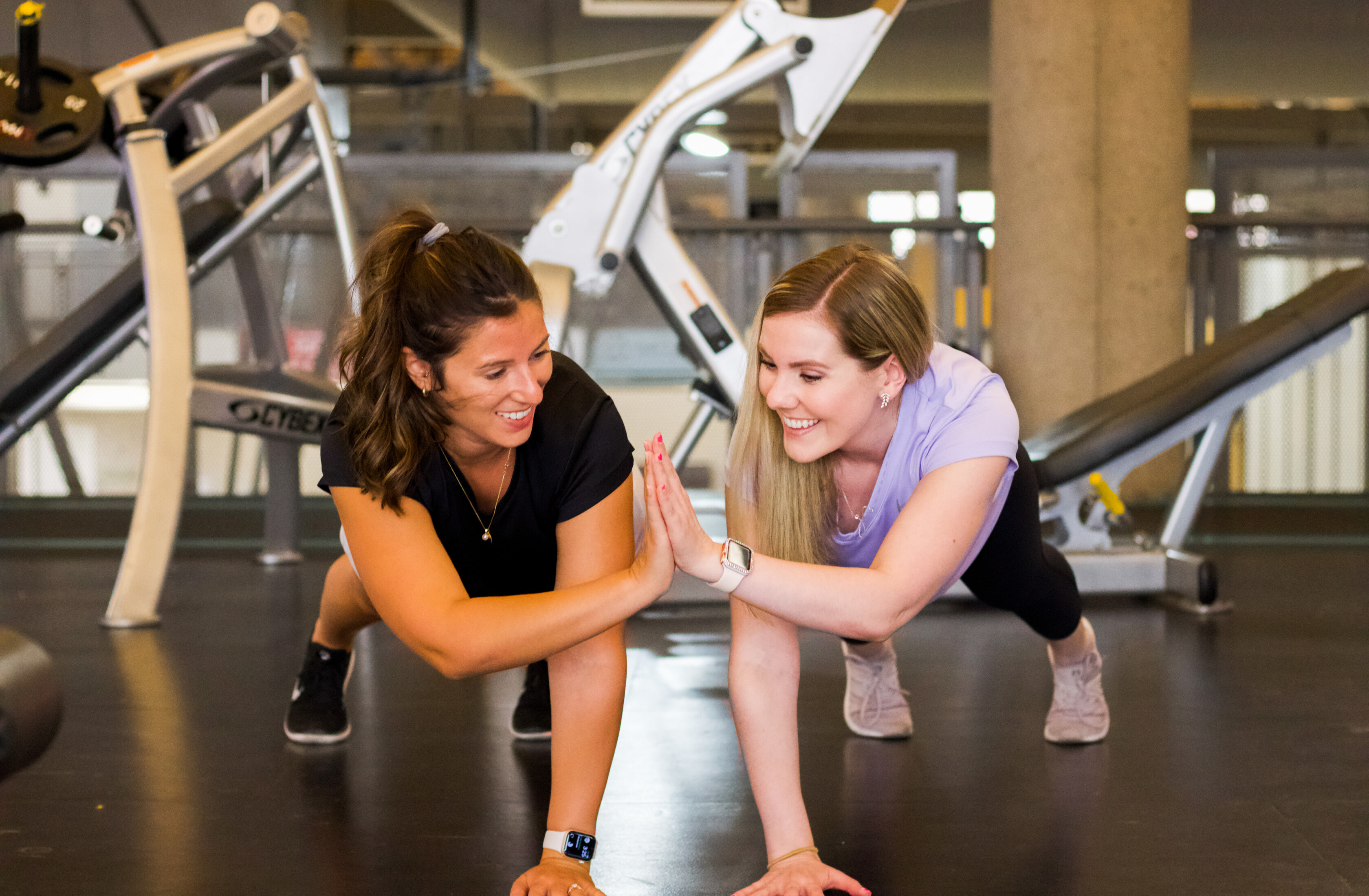 Two women working out together at a gym.