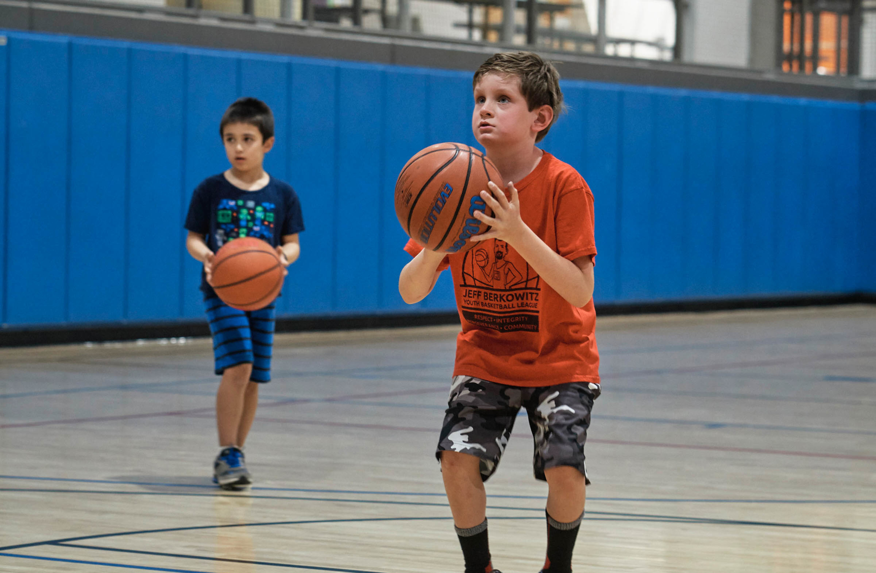 Two kids playing basketball.
