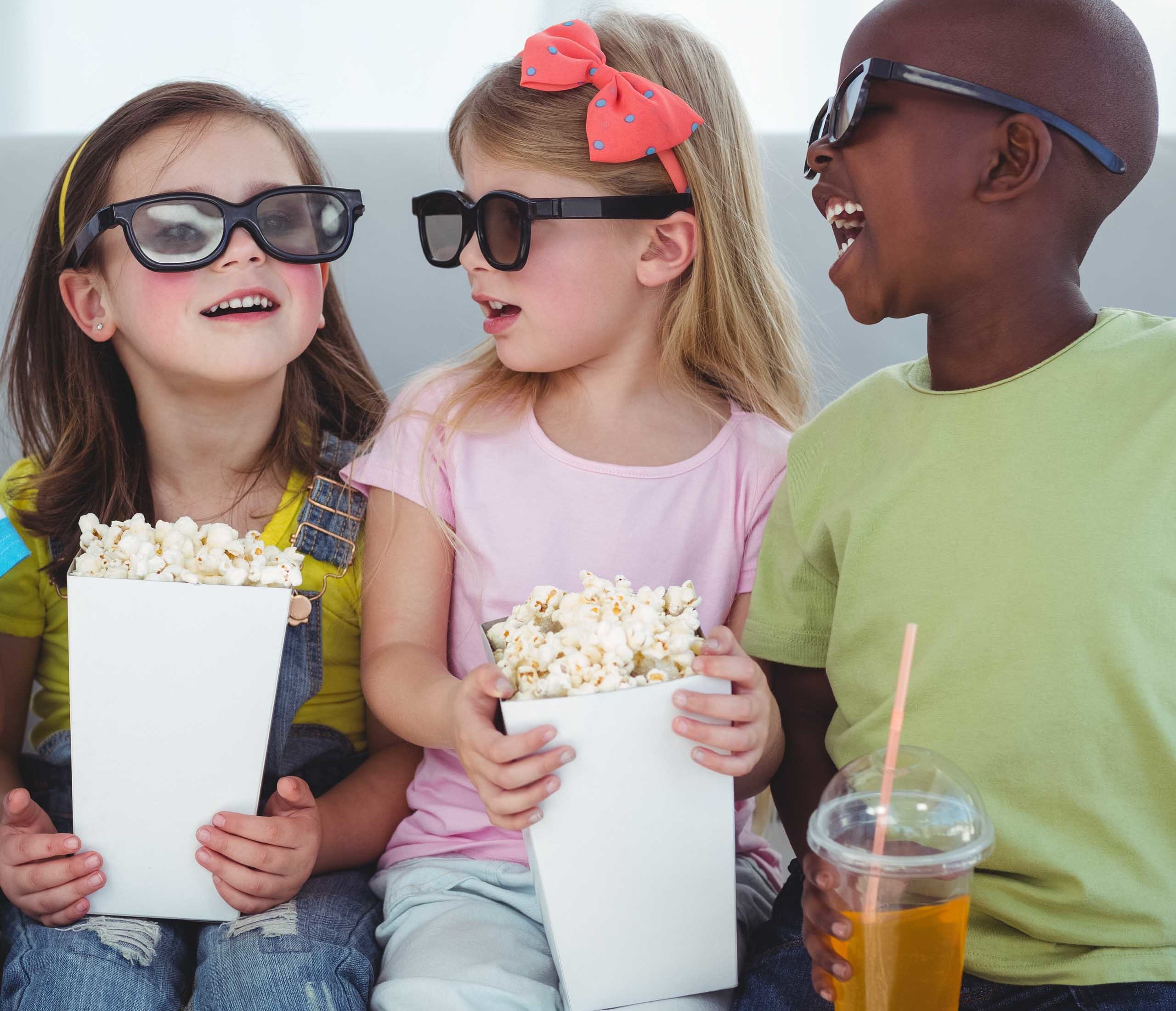 Three young kids ready to watch a movie.