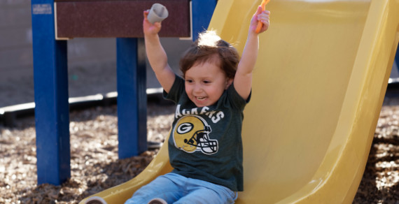 A child going down a yellow slide.