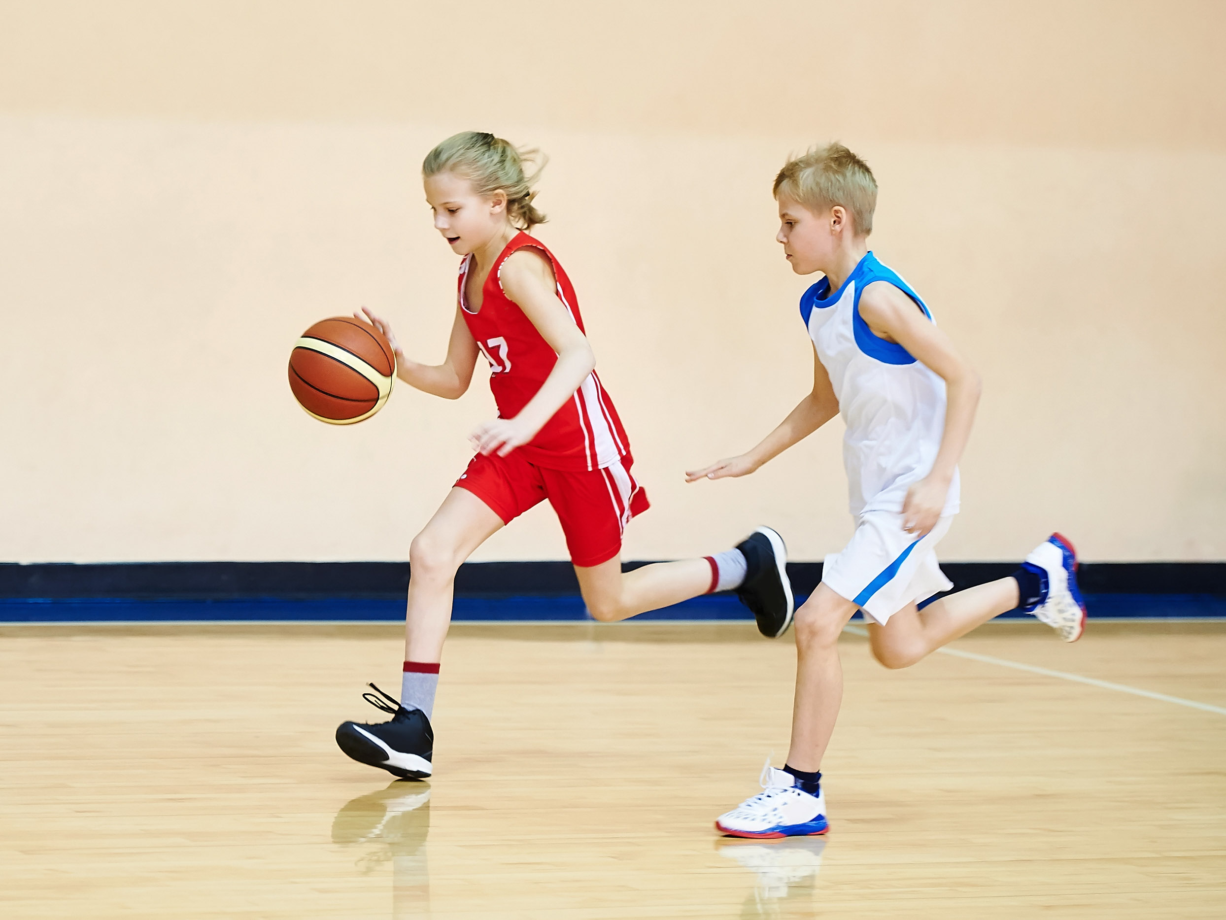 Two kids playing basketball.