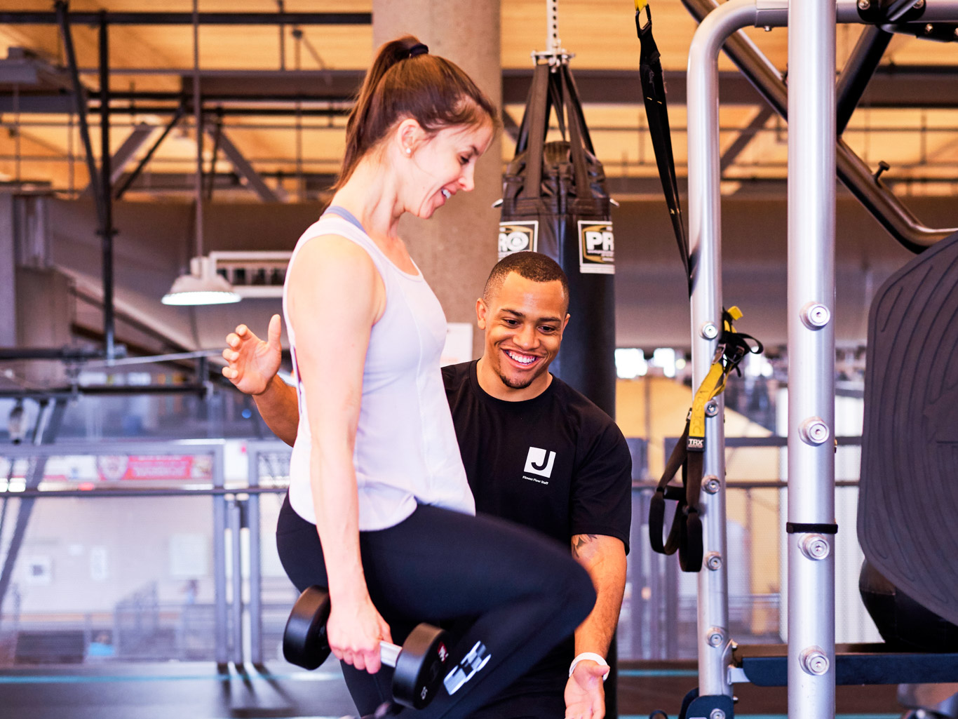 A woman with a personal trainer at a gym.