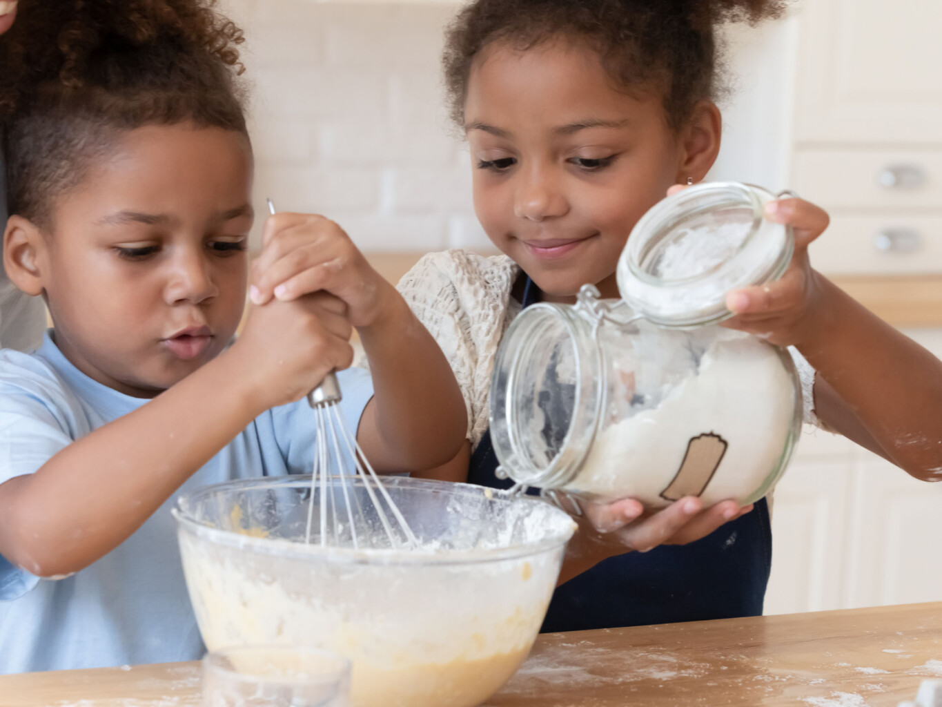 Two children baking.